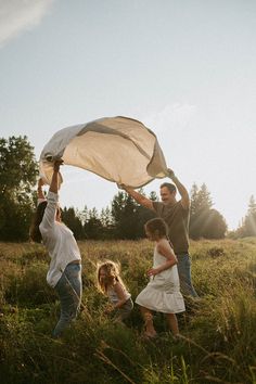 three people are in a field with a net over their heads and one person is holding the net above his head