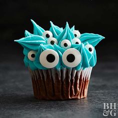 a cupcake decorated with blue frosting and googly eyes