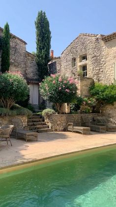 an outdoor swimming pool surrounded by stone buildings