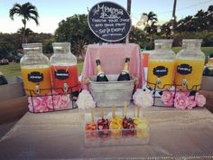 a table topped with drinks and fruit on top of a metal tray covered in plastic bottles