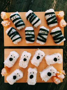 two cutting boards topped with sushi covered in black and white stripes, each being cut into smaller polar bears