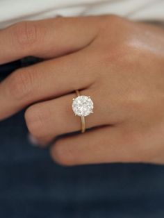 a woman's hand with a diamond ring on it