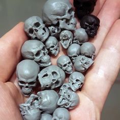 there are many skulls in the palm of someone's hand, and one is black