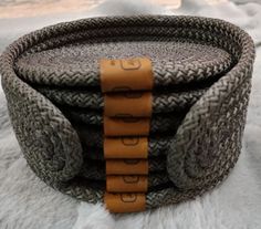 a close up of a woven basket on top of a white fur covered ground with an orange ribbon