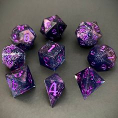 purple and silver dices with numbers on them sitting on a gray surface, all in the same pattern