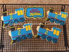 cookies decorated like trains are on a cooling rack with the words happy birthday written on them