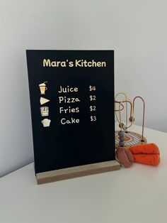 there is a menu board on the table next to some carrots and an egg carton