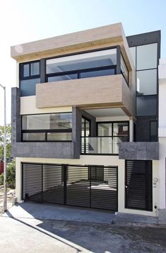 a modern house with black and white accents on the front, side and top floors