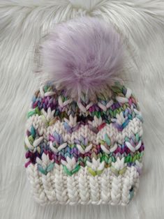 a multicolored knitted hat with a pom - pom