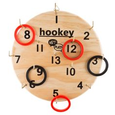 a wooden clock with red and black rings hanging from it's sides on a white background