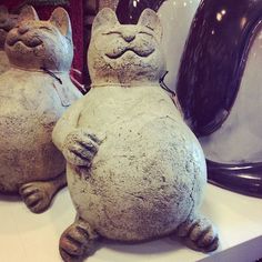 two cement cats sitting next to each other