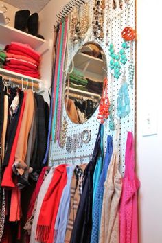 a closet filled with lots of colorful scarves and necklaces hanging on the wall