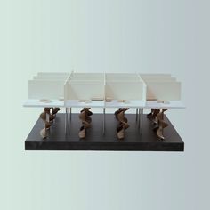 a group of four white desks sitting on top of a black table next to each other