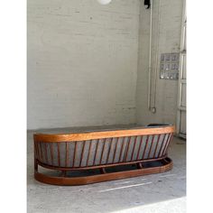 a wooden bench sitting in the middle of a room next to a white brick wall