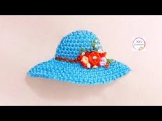 a crocheted blue hat with flowers on it