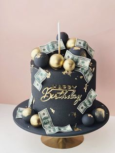 a black and gold birthday cake with money on top