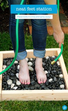 a person is standing on rocks with a hose attached to their feet and there are black stones in the ground