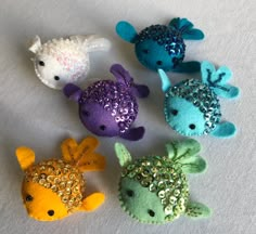 five different colored sea animals with sequins on them