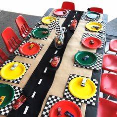 a table set up with race cars plates and napkins