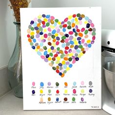 a card with a heart made out of colorful dots on it next to a mixer