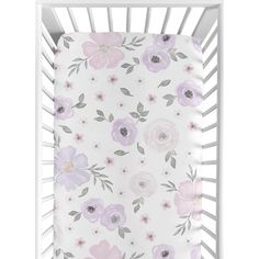 a white crib with pink and purple flowers on the side, in front of a white background