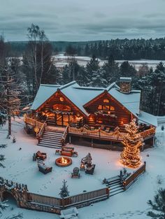 an aerial view of a large log cabin with christmas lights on the porch and deck