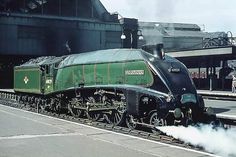 an old fashioned steam train is coming down the tracks