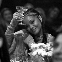 a black and white photo of a woman holding a wine glass in front of her face