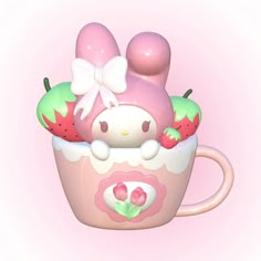 a hello kitty mug with strawberries and apples in it, on a pink background