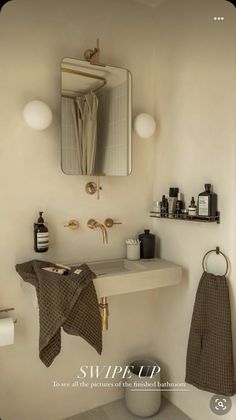 a bathroom with a sink, mirror and towel hanging on the wall next to it