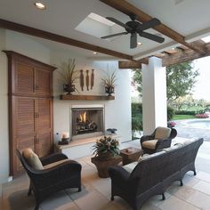 a living room filled with furniture and a fire place in front of a pool area