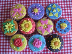 cupcakes decorated with flowers and bows on a checkered tablecloth