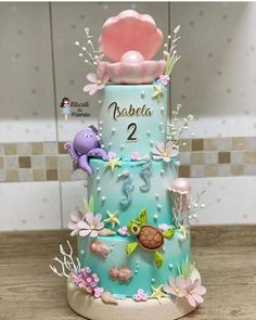 a three tiered cake decorated with sea animals and seashells