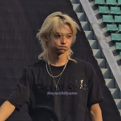 a young man with blonde hair wearing a black shirt