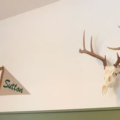 two deer heads mounted to the side of a wall next to a sign that says station