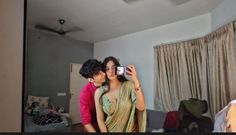 a man and woman taking a selfie in front of a mirror