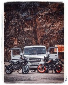 two motorcycles are parked next to a jeep