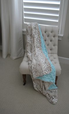 a white chair with a blue blanket on it