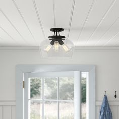 a light that is hanging from the ceiling in a room with white walls and wood flooring