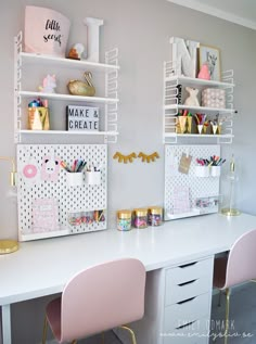 a white desk topped with two pink chairs next to a wall mounted shelf filled with craft supplies