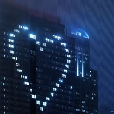 a very tall building with lots of windows in the city at night, lit up by street lights