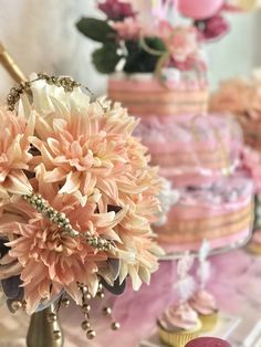 a table topped with lots of cakes and flowers