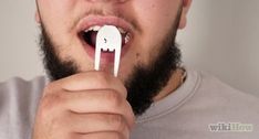 a man is brushing his teeth with an elephant shaped toothbrush in front of him