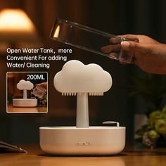 a person is pouring water into a cloud - shaped device on a table with other items