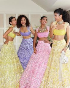 three women in colorful dresses standing next to each other and one is holding a purse