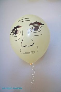 a balloon with an image of a man's face on it hanging from the wall