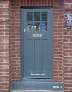 the front door to a brick building with a clock on it's side window