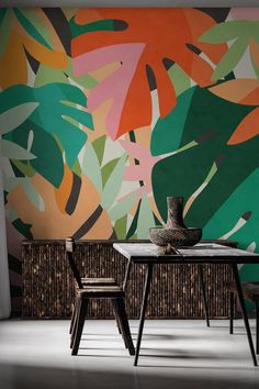 two chairs and a table in front of a colorful wall