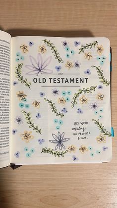 an open bible on a table with flowers and words written in the book, old testament