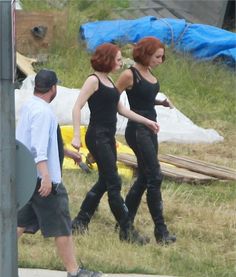 two women in black are walking down the street